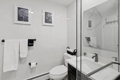 a white bathroom with a toilet and a sink at Group Retreat 15Min to NYC, MetLife, Mall, FREE Pa in North Bergen