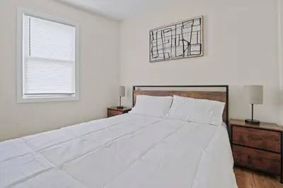 a white bedroom with a large bed and a window at Group Retreat 15Min to NYC, MetLife, Mall, FREE Pa in North Bergen