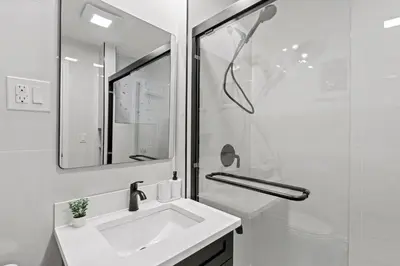 a white bathroom with a sink and a mirror at Group Retreat 15Min to NYC, MetLife, Mall, FREE Pa in North Bergen