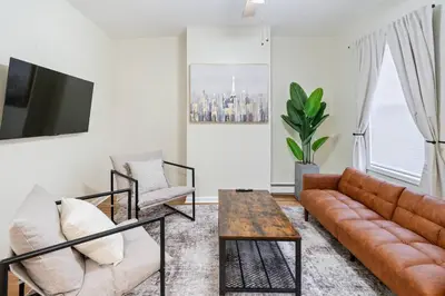 a living room with a couch and a table at Spacious 2BR - 15m to Times Square - FREE Parking in North Bergen