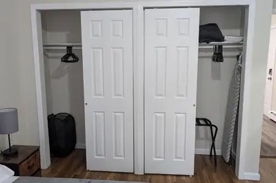 two white doors in a room with a bed at Spacious 2BR - 15m to Times Square - FREE Parking in North Bergen