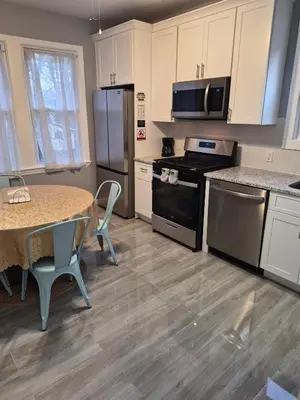 a kitchen with a table and a stove and refrigerator at Serene Haven of Tranquility in Maplewood