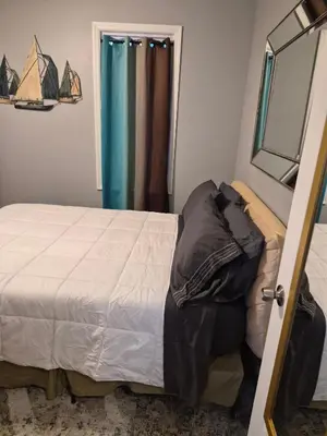 a bedroom with a bed and a mirror and a window at Serene Haven of Tranquility in Maplewood
