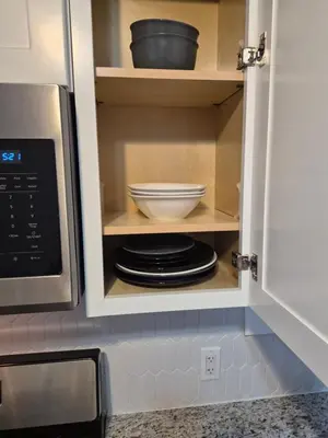 a cupboard with a bowl and plates in it at Serene Haven of Tranquility in Maplewood