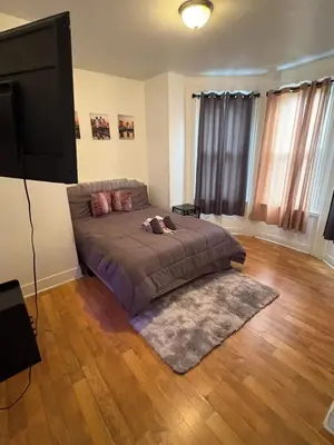 a bedroom with a bed and a flat screen tv at Charming 2 bedroom apartment in Philadelphia