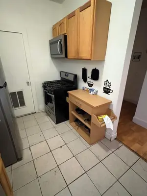a kitchen with a table and a stove and cabinets at Charming 2 bedroom apartment in Philadelphia