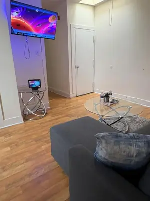 a living room with a table and a tv on the wall at Charming 2 bedroom apartment in Philadelphia
