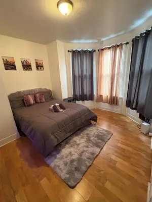 a bedroom with a bed and a wooden floor at Charming 2 bedroom apartment in Philadelphia