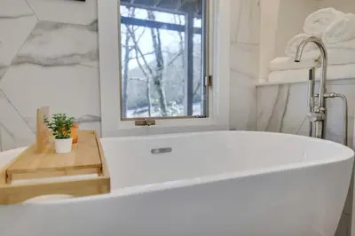 a white bath tub in a bathroom with a window at Mountain Top! Family Paradise w Hot Tub & Game Rm in Tannersville