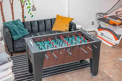 a living room with a foosball table in front of a couch at Mountain Top! Family Paradise w Hot Tub & Game Rm in Tannersville