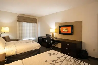 a hotel room with two beds and a desk at Express Inn & Suites in Harrisburg