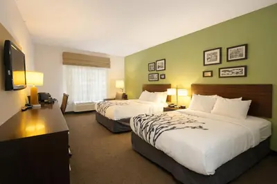 a hotel room with two beds and a flat screen tv at Express Inn & Suites in Harrisburg