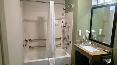a bathroom with a shower with a tub and a sink at Express Inn & Suites in Harrisburg