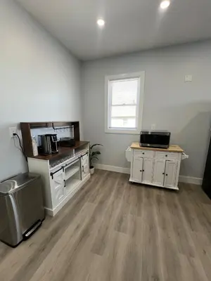 an empty kitchen with white cabinets and a window at 2Bed Gem-15min to NYC-3min Walk to Bus-Train in North Bergen