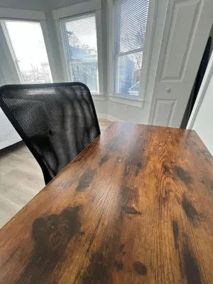a wooden table and a black chair in a room at 2Bed Gem-15min to NYC-3min Walk to Bus-Train in North Bergen