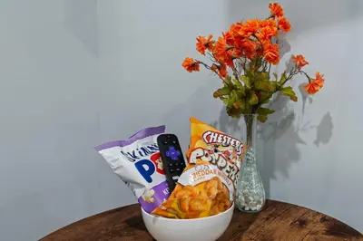 a table with a bowl of chips and a vase with flowers at Cozy Convenient 1 Bedroom with 2 Beds Near Downtown in Philadelphia