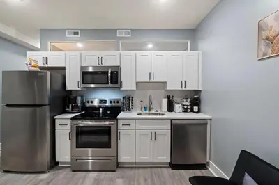 a kitchen with white cabinets and stainless steel appliances at Cozy Convenient 1 Bedroom with 2 Beds Near Downtown in Philadelphia