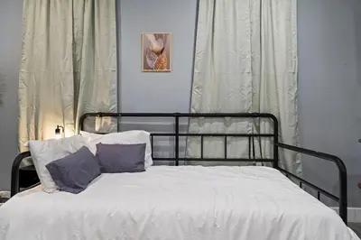 a bed with white sheets and purple pillows at Cozy Convenient 1 Bedroom with 2 Beds Near Downtown in Philadelphia