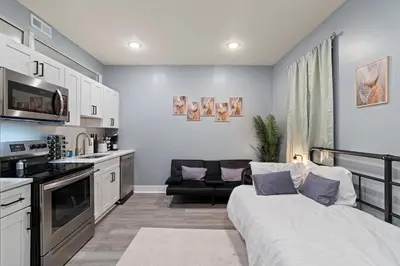 a living room with a bed and a kitchen at Cozy Convenient 1 Bedroom with 2 Beds Near Downtown in Philadelphia