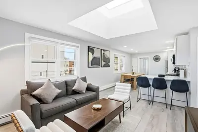 a living room with a couch and a table at Spacious 2BR Apt with Balcony only 15 Min Bus to Manhattan in Jersey City