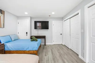 a bedroom with a bed and a tv on a wall at Spacious 2BR Apt with Balcony only 15 Min Bus to Manhattan in Jersey City