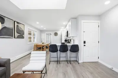 a kitchen and living room with a table and chairs at Spacious 2BR Apt with Balcony only 15 Min Bus to Manhattan in Jersey City