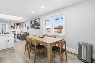 a kitchen and dining room with a table and chairs at Spacious 2BR Apt with Balcony only 15 Min Bus to Manhattan in Jersey City