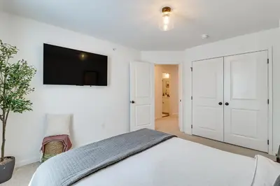 a bedroom with a bed and a tv on the wall at Half-Mi to the Triangle! Chic Emmaus Townhome