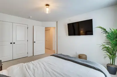 a bedroom with a bed and a tv on the wall at Half-Mi to the Triangle! Chic Emmaus Townhome
