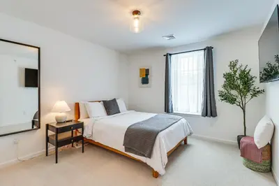 a bedroom with a bed and a large window at Half-Mi to the Triangle! Chic Emmaus Townhome