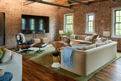 a living room with brick walls and a couch and chairs at Eleanor Inn - Suite Amelia & Lorena in Warwick