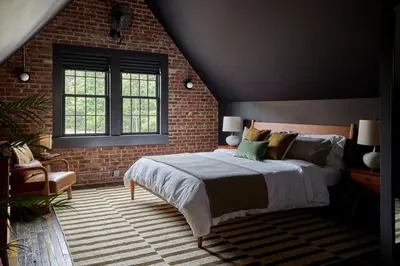 a bedroom with a bed and a brick wall at Eleanor Inn - Suite Amelia & Lorena in Warwick