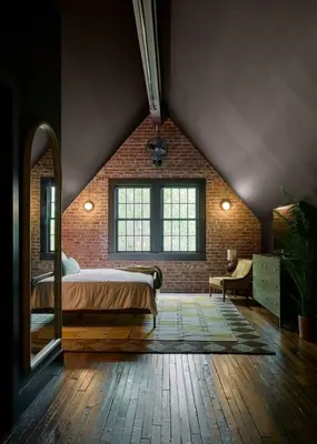 a bedroom with a bed and a brick wall at Eleanor Inn - Suite Amelia & Lorena in Warwick