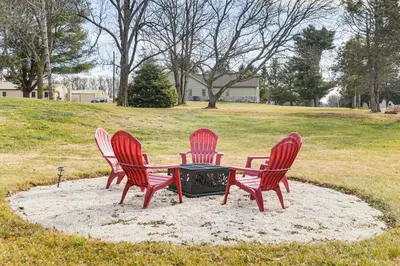 three red chairs sitting around a table in a field at Family-Friendly Home, 5 Mi to Roundtop Mtn Resort! in Dillsburg