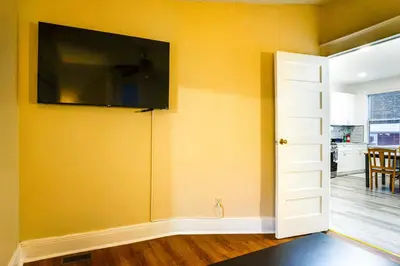 a room with a tv on a yellow wall at Easy NYC Access! Gateway Region Apartment with Yard in West New York