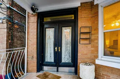 a black front door of a brick house at Easy NYC Access! Gateway Region Apartment with Yard in West New York