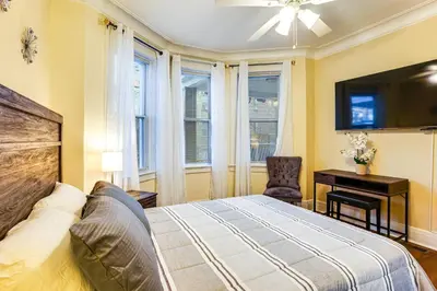 a bedroom with a bed and a desk and windows at Easy NYC Access! Gateway Region Apartment with Yard in West New York