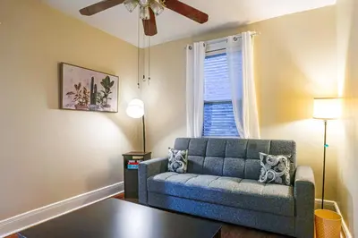a living room with a blue couch and a window at Easy NYC Access! Gateway Region Apartment with Yard in West New York