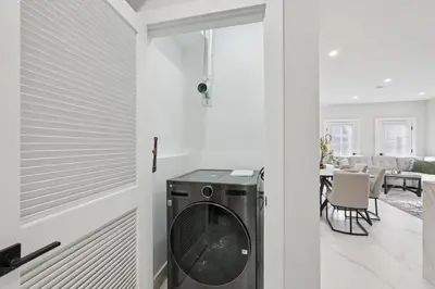 a washer and dryer in a living room next to a door at Furnished Private room with shared spaces in Jersey City