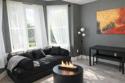 a living room with a couch and a fire place at Midnight Ember Moody City 1BR Escape in Philadelphia