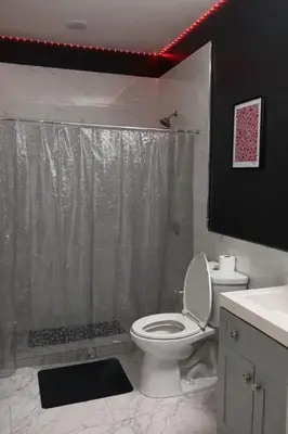 a bathroom with a white toilet and a shower at Midnight Ember Moody City 1BR Escape in Philadelphia