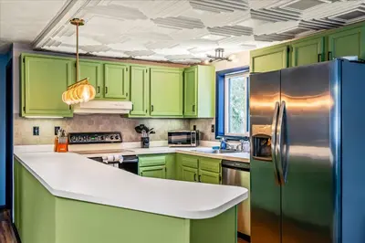 a kitchen with green cabinets and a refrigerator at Movie Theater Game Room Resort Amenity Access in Tobyhanna