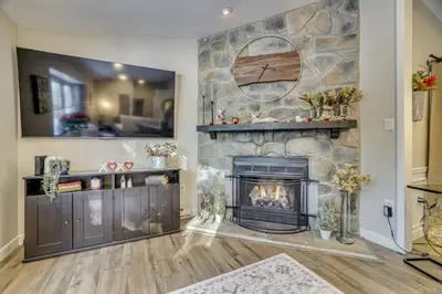 a fireplace in a living room with a stone wall at Newly Renovated! Peaceful Saylorsburg Home in Saylorsburg