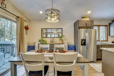 a kitchen with a table with chairs and a refrigerator at Newly Renovated! Peaceful Saylorsburg Home in Saylorsburg