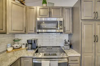 a kitchen with a stove and a microwave at Newly Renovated! Peaceful Saylorsburg Home in Saylorsburg