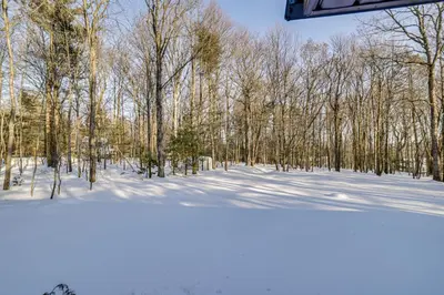 a snow covered field with trees in the background at Newly Renovated! Peaceful Saylorsburg Home in Saylorsburg
