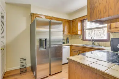 a kitchen with a stainless steel refrigerator and wooden cabinets at Pet Friendly and WFH Ready! Quiet Hudson Valley Apt in Newburgh