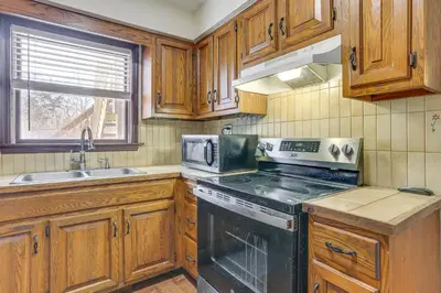 a kitchen with wooden cabinets and a stove top oven at Pet Friendly and WFH Ready! Quiet Hudson Valley Apt in Newburgh