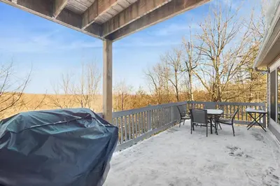 a covered porch with a table and chairs on it at Mountain View Memories at Northridge in Tannersville