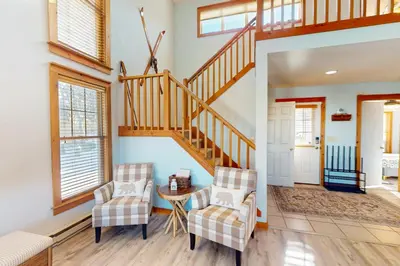 a living room with two chairs and a staircase at Mountain View Memories at Northridge in Tannersville